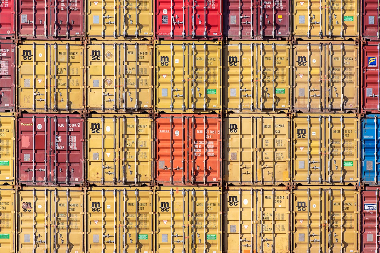 Vibrant array of stacked shipping containers in various colors creating a geometric pattern.