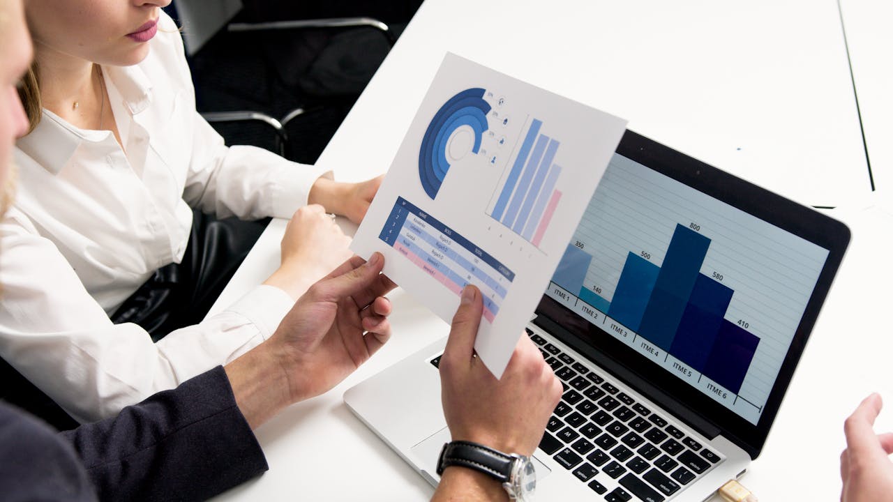 our-story Business professionals discussing data charts and graphs in a modern office setting.